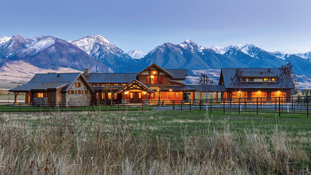 Montana ranch house with Rocky Mountains in the background, symbolizing stability, trust, and Montana roots.
